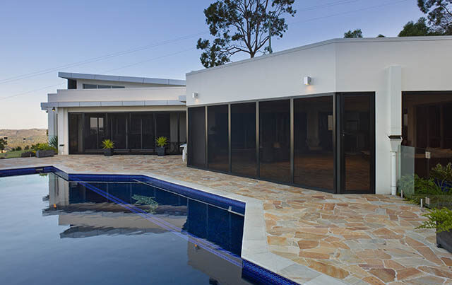 House and outdoor pool area shown to detail the use of window security screens.